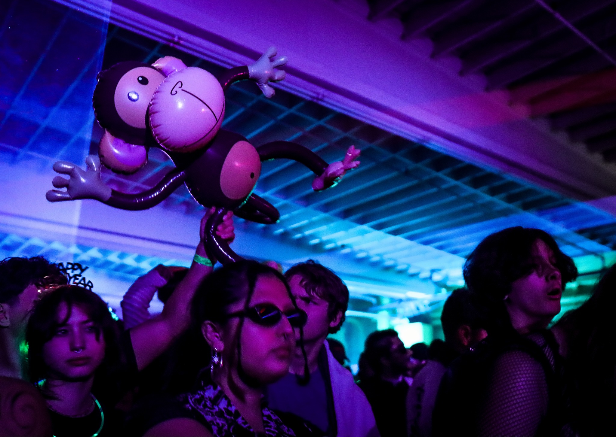 Stage lights cutting through haze at underground rave in San Diego